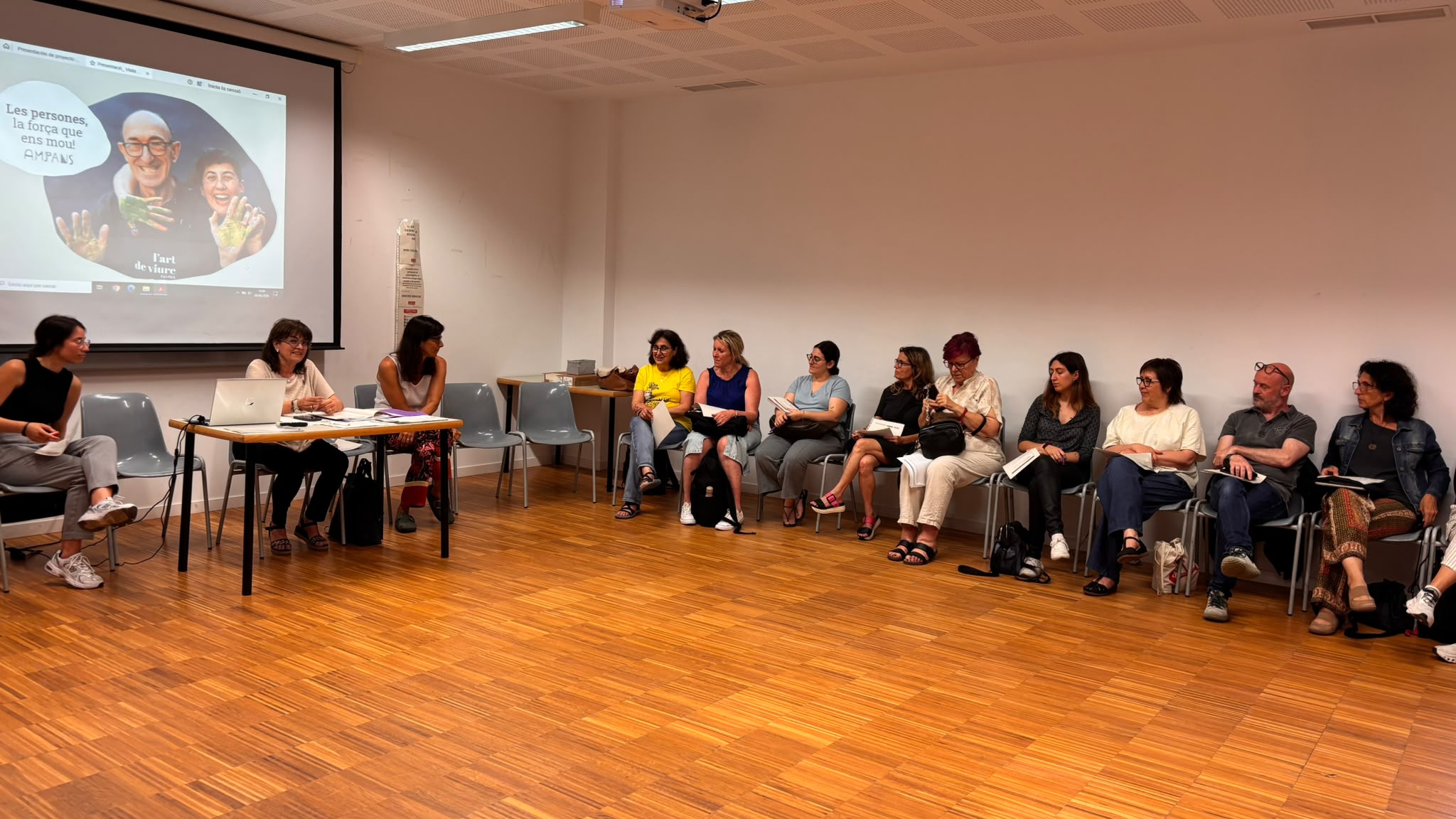Fotografia de les persones assitents a la reunió, només és veu la meitat de la sala